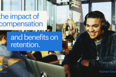 smiling man looks at laptop in lounge area: the impact of compensation and benefits on retention